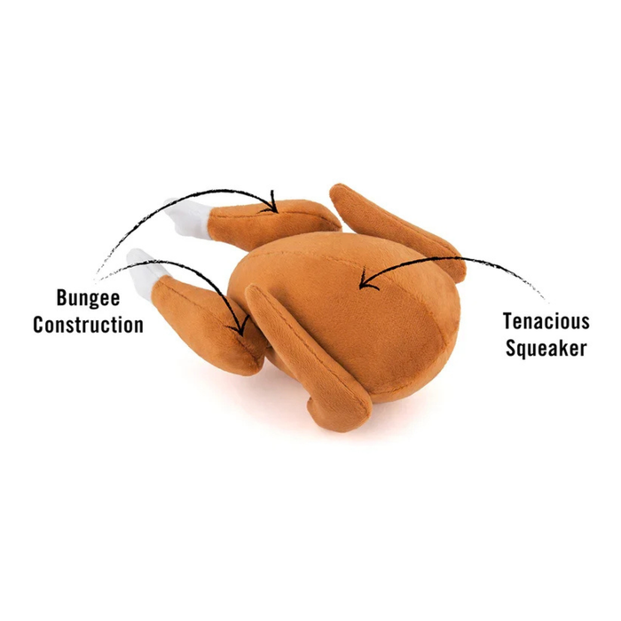 Demonstration of features for the plush turkey toy. It indicates a squeaker in the main body of the toy, with the two drumsticks connected by an internal bungee cord that passes through the toy, allowing for tug play.